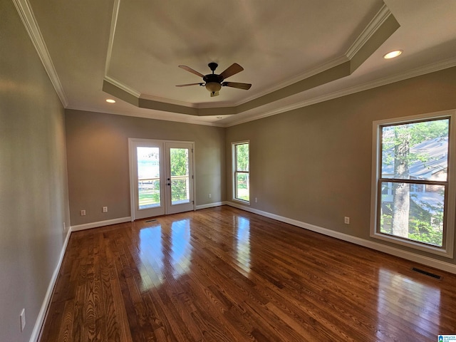 spare room with crown molding, hardwood / wood-style floors, and a tray ceiling