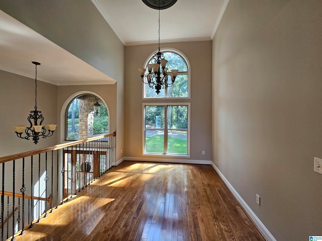 interior space with ornamental molding, a chandelier, and hardwood / wood-style flooring