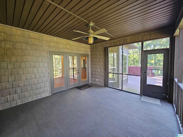 unfurnished sunroom with ceiling fan, wooden ceiling, and french doors