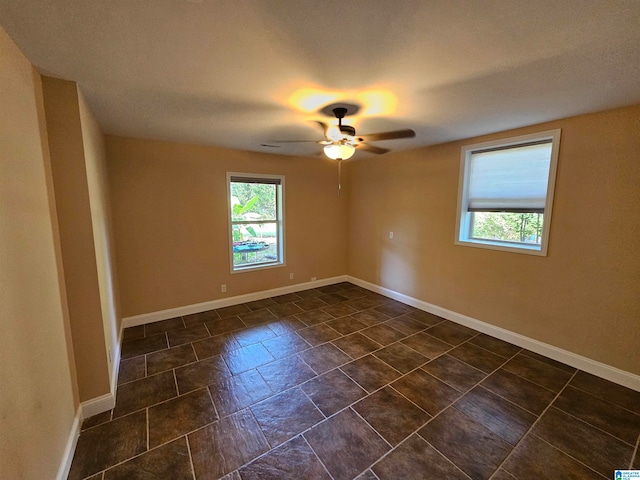 tiled spare room featuring ceiling fan