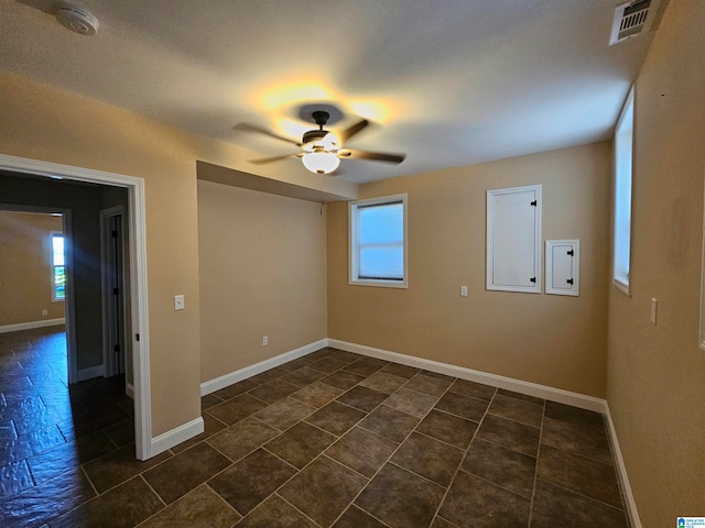 tiled spare room with ceiling fan