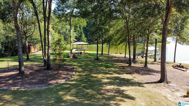 surrounding community with a water view, a yard, and a gazebo