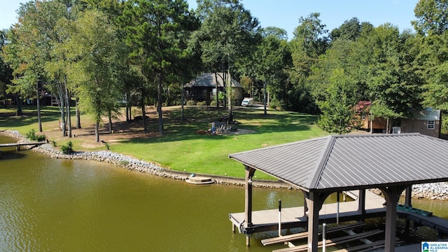 view of dock with a water view and a lawn