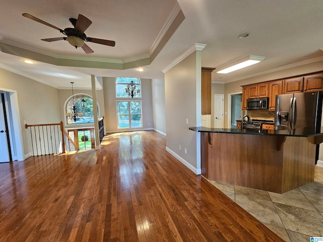 kitchen featuring hardwood / wood-style floors, a kitchen breakfast bar, stainless steel appliances, and kitchen peninsula