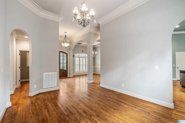 interior space featuring an inviting chandelier, ornamental molding, and hardwood / wood-style flooring