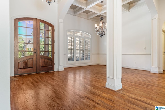 entrance foyer featuring french doors, coffered ceiling, a chandelier, hardwood / wood-style flooring, and beam ceiling