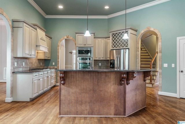 kitchen featuring a center island, light hardwood / wood-style flooring, hanging light fixtures, and stainless steel appliances