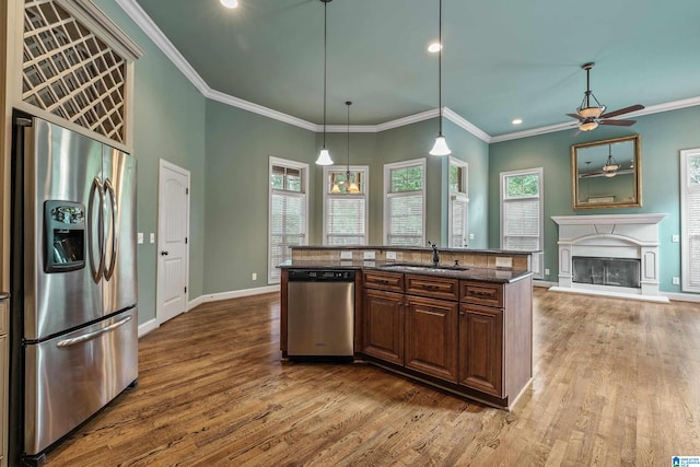 kitchen with sink, a center island with sink, appliances with stainless steel finishes, dark hardwood / wood-style flooring, and pendant lighting