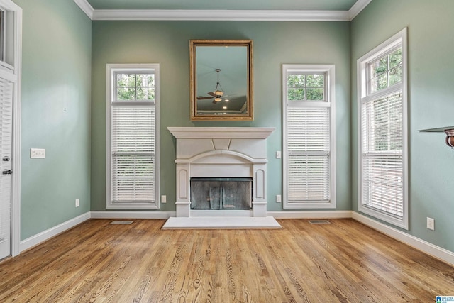 unfurnished living room featuring crown molding, light wood-type flooring, and ceiling fan