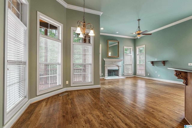 unfurnished living room featuring hardwood / wood-style flooring, ornamental molding, and ceiling fan with notable chandelier