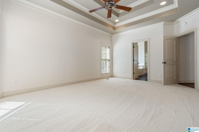 unfurnished room with a raised ceiling, ornamental molding, carpet, and ceiling fan