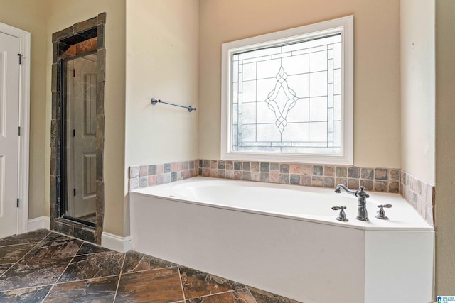 bathroom with a wealth of natural light and shower with separate bathtub