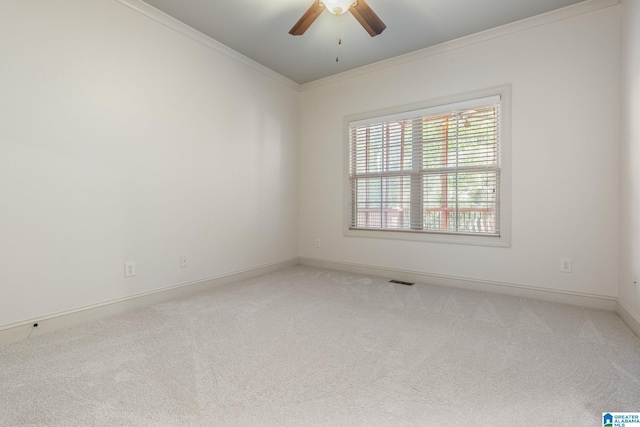 empty room with ceiling fan, ornamental molding, and carpet