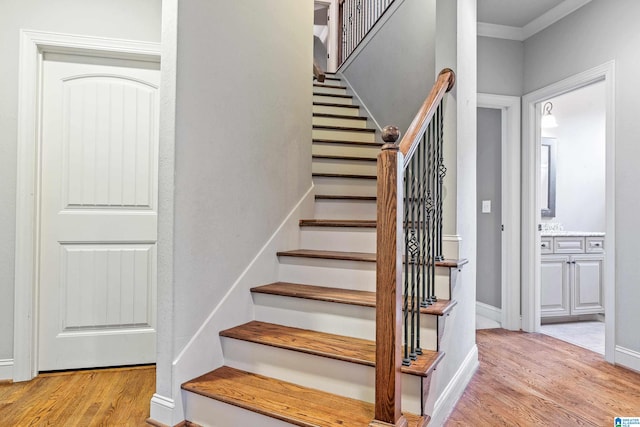 stairway featuring crown molding and wood-type flooring