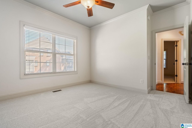 carpeted empty room with crown molding and ceiling fan