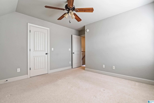 unfurnished bedroom with vaulted ceiling, light colored carpet, and ceiling fan