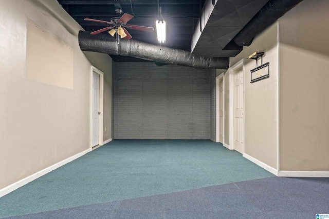 basement with ceiling fan, brick wall, and carpet floors