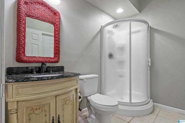 bathroom featuring a shower with door, vanity, tile patterned floors, and toilet