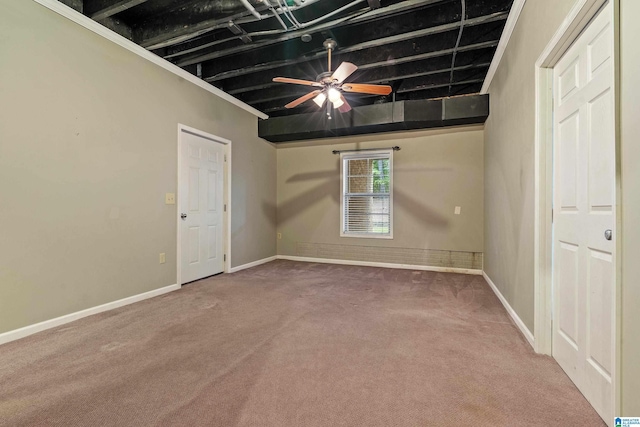 carpeted empty room with beamed ceiling and ceiling fan