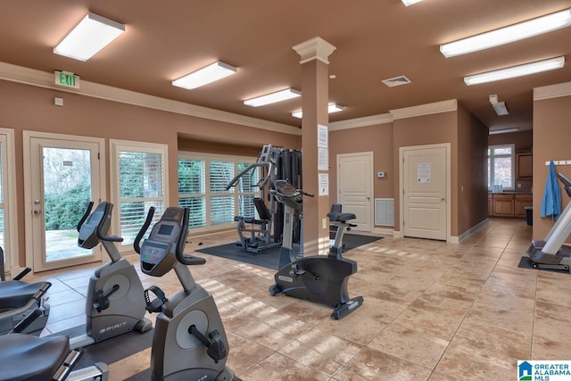 gym featuring light tile patterned flooring, plenty of natural light, ornamental molding, and ornate columns