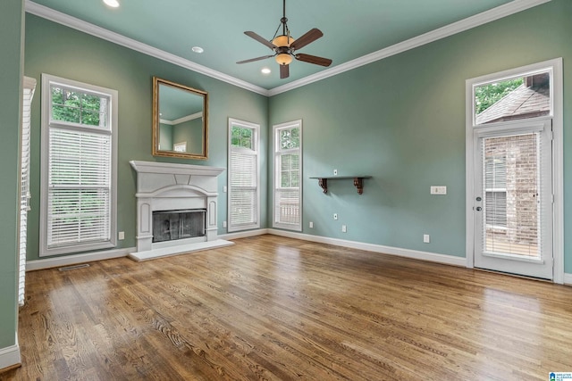 unfurnished living room featuring hardwood / wood-style flooring, ornamental molding, and plenty of natural light