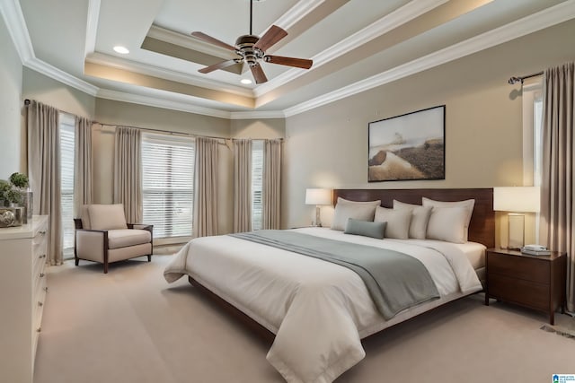 carpeted bedroom featuring crown molding, ceiling fan, and a raised ceiling