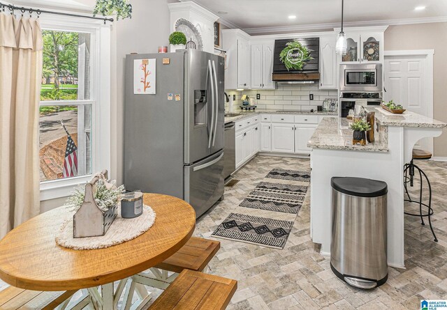 kitchen featuring light hardwood / wood-style floors, white cabinetry, a barn door, and pendant lighting