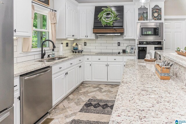 kitchen featuring crown molding, tasteful backsplash, white cabinets, a center island, and stainless steel appliances