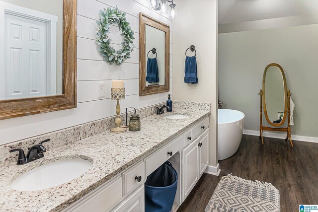 bedroom featuring ensuite bath and dark wood-type flooring