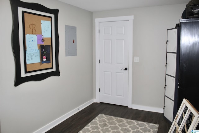 interior space with dark wood finished floors, electric panel, and baseboards