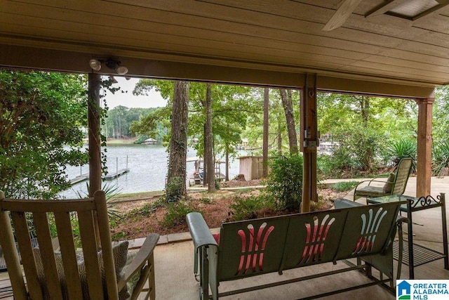 sunroom / solarium featuring a water view and wood ceiling