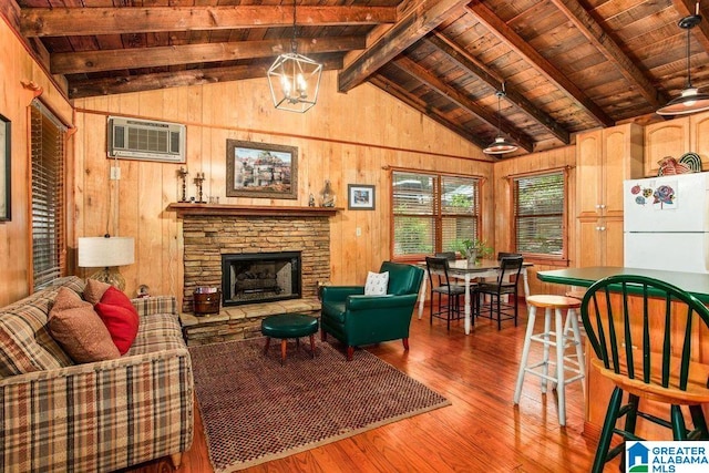 living area featuring wood finished floors, wood walls, lofted ceiling with beams, and a wall mounted AC