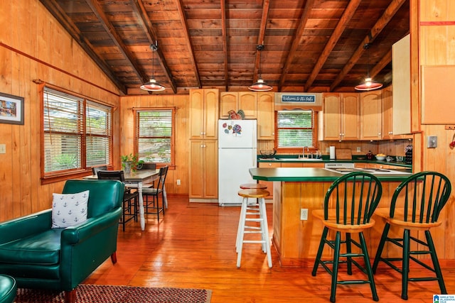 kitchen with wooden ceiling, wooden walls, hardwood / wood-style floors, and freestanding refrigerator