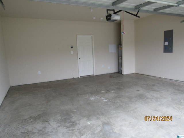 garage featuring strapped water heater, electric panel, and a garage door opener