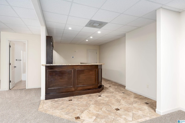 interior space featuring light tile patterned flooring and a drop ceiling