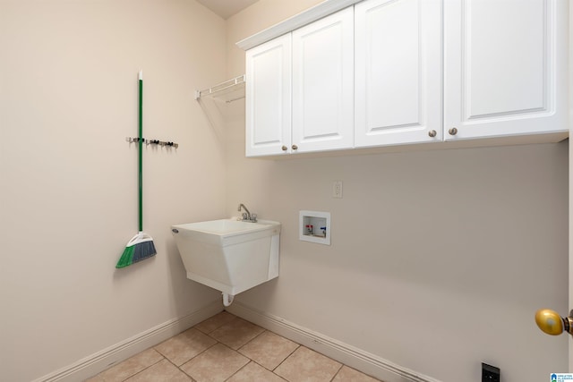 washroom featuring sink, washer hookup, cabinets, and light tile patterned floors