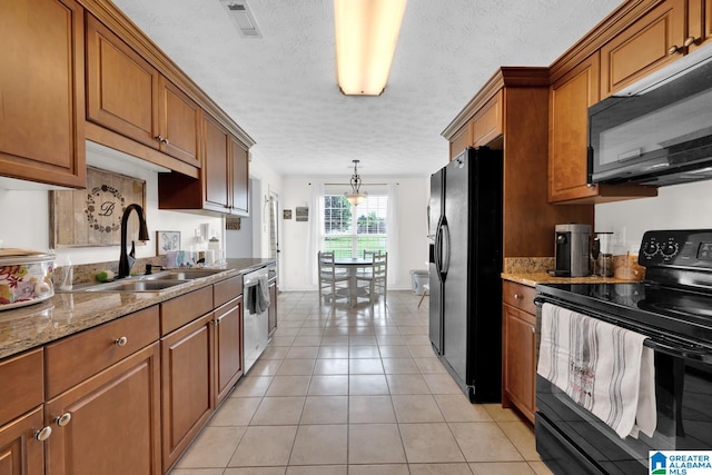 kitchen featuring pendant lighting, light tile patterned flooring, sink, black appliances, and light stone counters