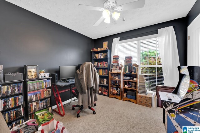 carpeted home office with ceiling fan and a textured ceiling