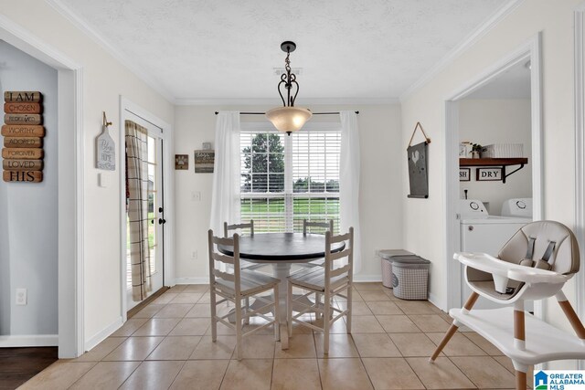 dining room featuring light tile patterned floors, washing machine and dryer, a textured ceiling, and crown molding