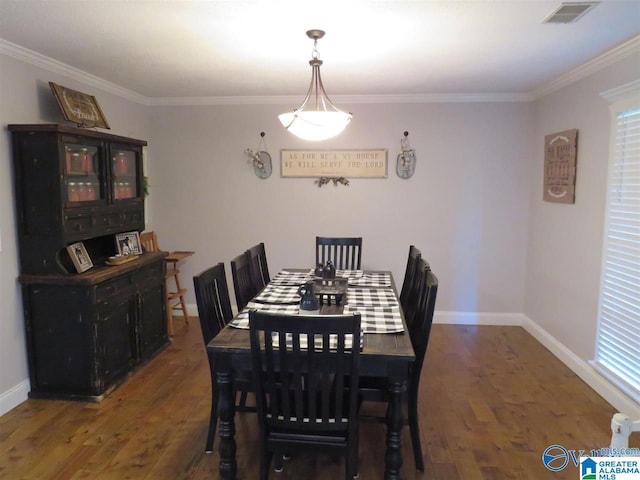 dining room featuring ornamental molding and dark hardwood / wood-style flooring