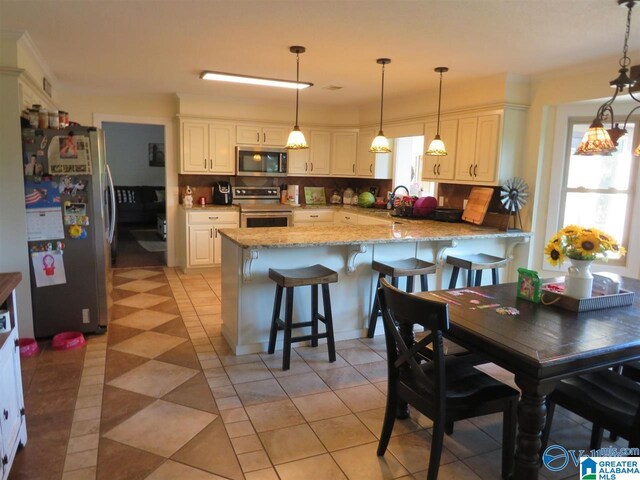 kitchen with pendant lighting, kitchen peninsula, tasteful backsplash, and stainless steel appliances