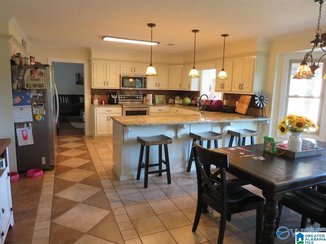 kitchen featuring pendant lighting, a kitchen breakfast bar, stainless steel appliances, and kitchen peninsula