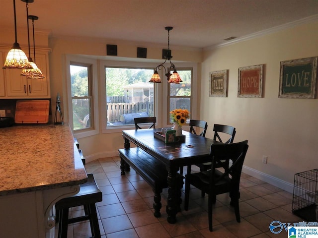 dining room with crown molding and dark tile patterned flooring