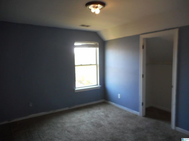 unfurnished bedroom with lofted ceiling, carpet flooring, and a closet