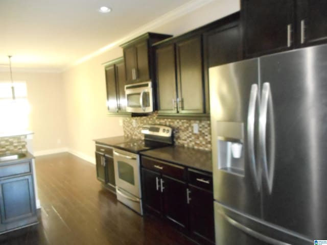 kitchen with white appliances, backsplash, decorative light fixtures, crown molding, and dark hardwood / wood-style floors