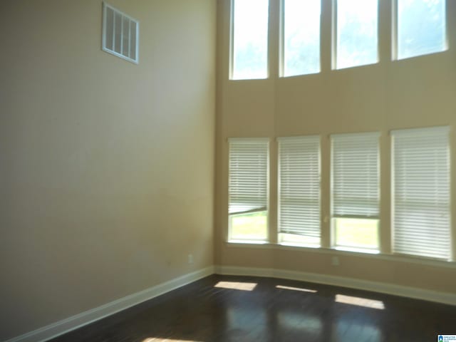 empty room with hardwood / wood-style floors and a healthy amount of sunlight