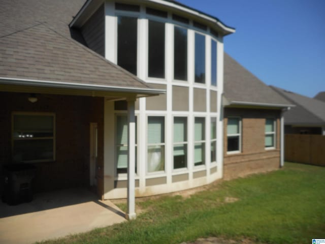 rear view of property with a sunroom and a lawn