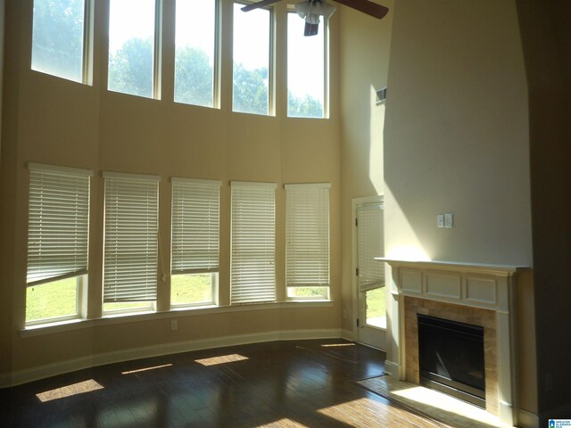 unfurnished living room featuring a healthy amount of sunlight, hardwood / wood-style flooring, and ceiling fan