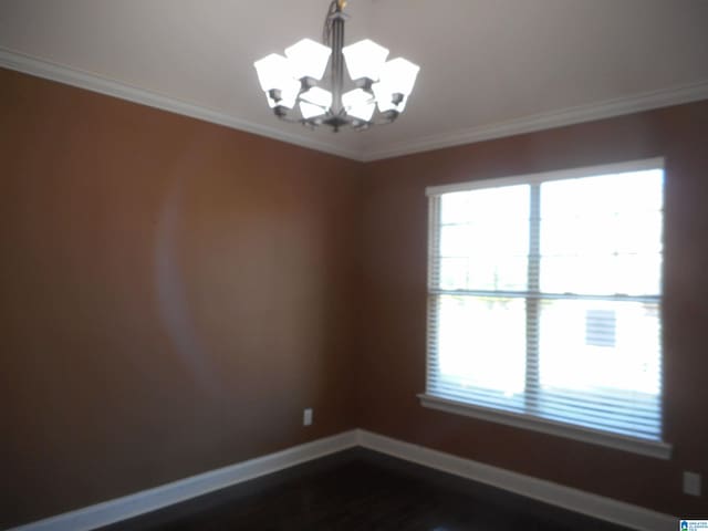 spare room with ornamental molding and a chandelier