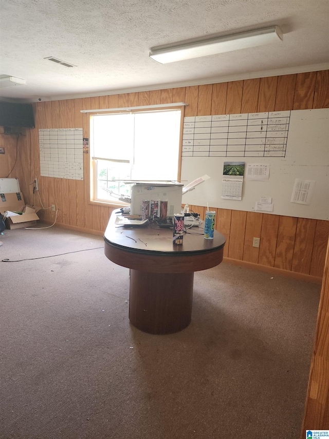 home office with wood walls, carpet, and a textured ceiling